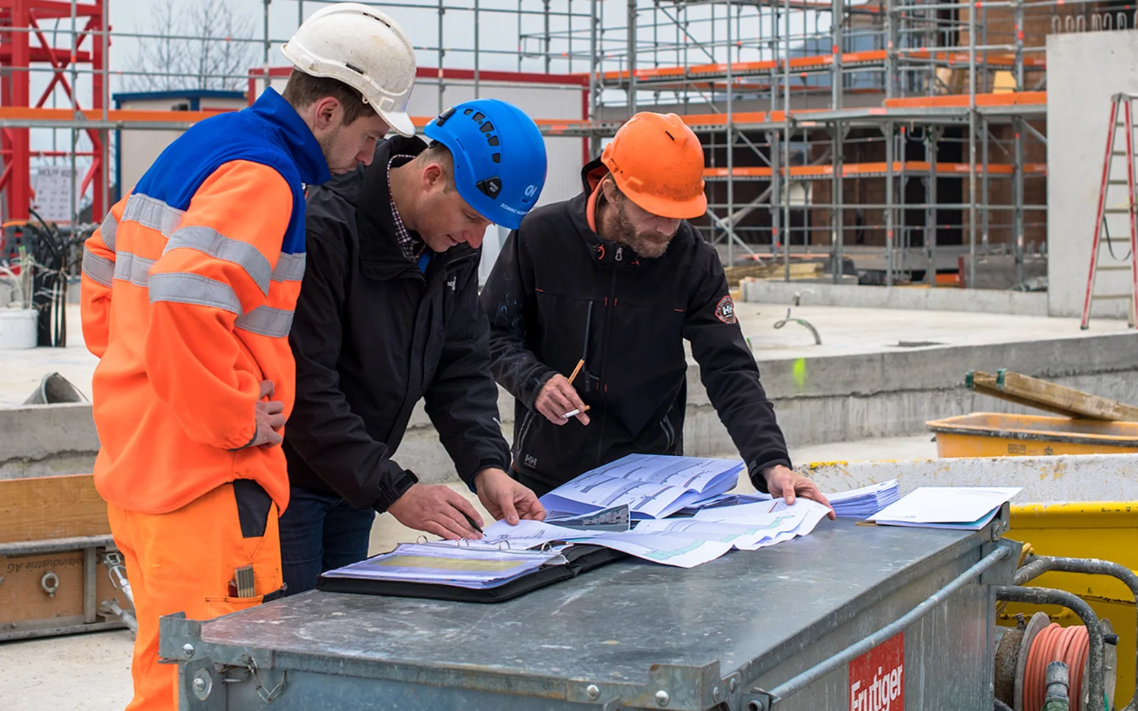 Stark Bau Team bespricht Baupläne direkt auf der Baustelle