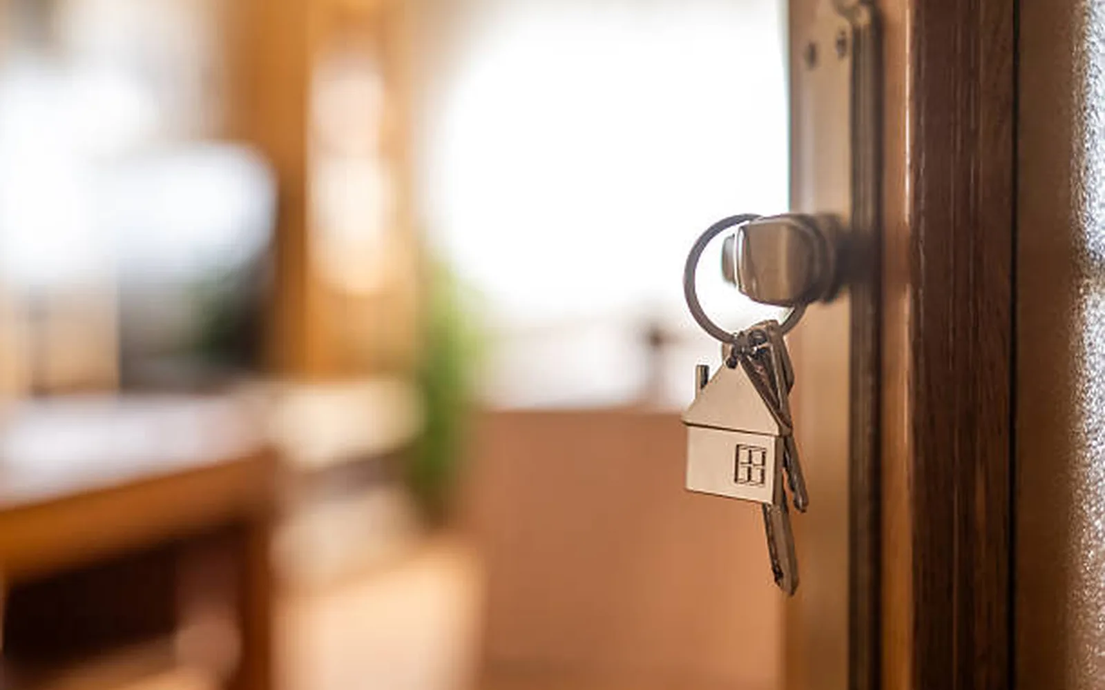Schlüssel mit Hausanhänger in einer Wohnungstüre nach der Übergabe